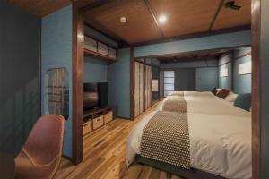 a bedroom with a large bed and a flat screen tv at Higashiyama bau in Kanazawa