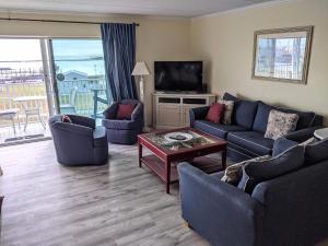 a living room with blue couches and a television at 210 Worchester St #405 in Ocean City