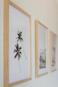 two framed pictures of a palm tree on a wall at MAREA New 2 BDR Beachfront by Casa Paraíso in Cancún