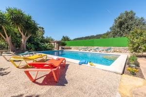 a swimming pool with two lounge chairs next to a swimming pool at Finca Xesca in Sóller