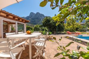 a patio with a table and chairs and a pool at Finca Xesca in Sóller