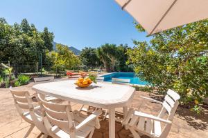 a white table and chairs with a bowl of fruit on it at Finca Xesca in Sóller