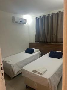 a room with two beds and a window at HANNA Arcos d'Atalaia Hotel - Aracaju in Aracaju