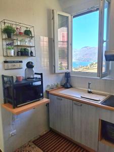 eine Küche mit Spüle und Fenster in der Unterkunft Luna Serena in Luino