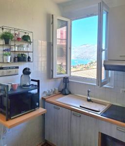 eine Küche mit Spüle und Fenster in der Unterkunft Luna Serena in Luino