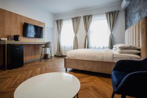ein Hotelzimmer mit Bett und Fernseher in der Unterkunft Aristide House - Premium Luxury Self Check-in Rooms and Suites in Bukarest + 41 Fotos