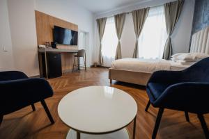 een hotelkamer met een bed, een tafel en stoelen bij Aristide House in Boekarest