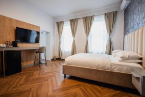 a bedroom with a bed and a flat screen tv at Aristide House in Bucharest