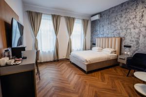 布加勒斯特Aristide House的一间卧室，配有一张床和一张带电脑的书桌