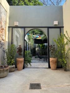 an open doorway to a patio with potted plants at Casa Ramon Merida 2 BR AC Private Pool Centro in Mérida