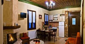 a kitchen and living room with a table and a fireplace at Atrapos in Karpenisi