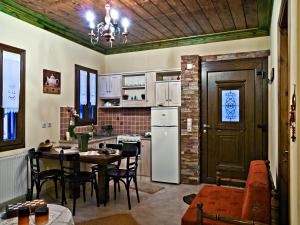 a kitchen with a table and a white refrigerator at Atrapos in Karpenisi