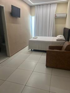 a hospital room with a bed and a couch at HANNA Arcos d'Atalaia Hotel - Aracaju in Aracaju