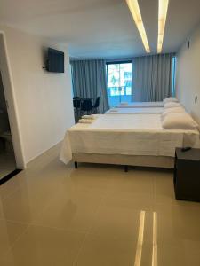 a large bedroom with a large bed and a window at HANNA Arcos d'Atalaia Hotel - Aracaju in Aracaju