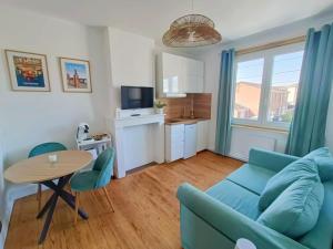 a living room with a blue couch and a table at Escapade Béthunoise in Béthune