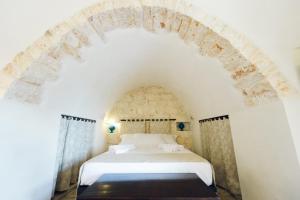 A bed or beds in a room at Masseria Macchia