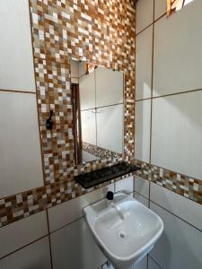 un bagno con lavandino e specchio di Flat Maré mansa - Praia - bicas - belezas naturais a Japaratinga Altre 23 foto