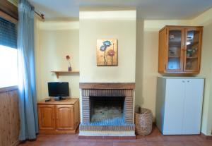 Robledillo de la JaraAlojamientos Poseidon的带壁炉和电视的客厅