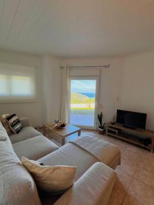 un soggiorno con due divani e una televisione di Tramontana House1 a Città di Skiathos