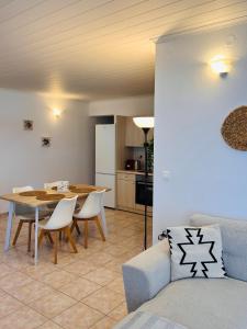 un soggiorno con tavolo e sedie e una cucina di Tramontana House1 a Città di Skiathos