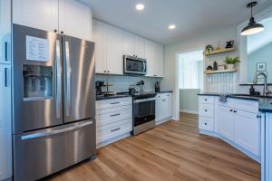 a kitchen with white cabinets and a stainless steel refrigerator at New Remodel! 4BR Near DT Cartersville & Major Hwys in Cartersville