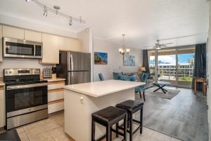 a kitchen and living room with a counter and chairs at Maui Banyan H506 in Wailea