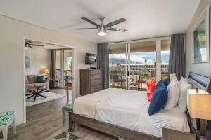 a bedroom with a bed and a balcony at Maui Banyan H506 in Wailea +24 photos