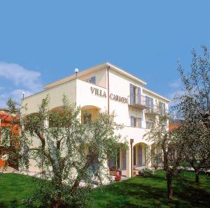 een wit gebouw met een bord aan de zijkant bij Residence Villa Carmen fronte mare a 50 mt in Pietra Ligure