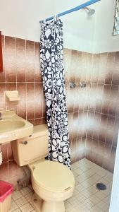 a bathroom with a toilet and a shower curtain at Arena Surf Hotel, Puerto Escondido in Puerto Escondido