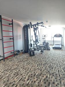 une salle de sport avec plusieurs tapis de course et vélos dans une pièce dans l'établissement Apartament 104 Wind w Welle, à Grzybowo