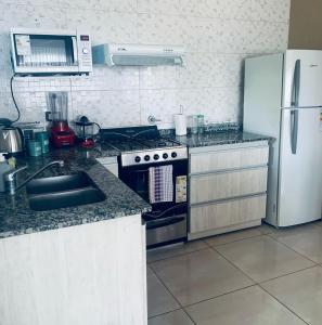a kitchen with a stove and a refrigerator at Casamar La Caleta in Mar de Cobo