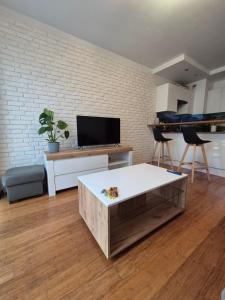 un soggiorno con tavolino e TV di Apartament Szklane Tarasy a Rzeszów