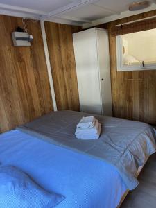 a bedroom with a bed with blue sheets and a window at Ibiza style chalet in Eext
