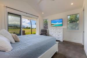 a bedroom with a bed and a dresser and a window at Tradewinds in Princeville +19 photos