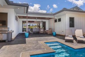 a backyard with a swimming pool and a house at Tradewinds in Princeville