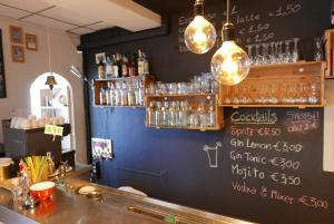 un bar avec un mur bleu et un panneau de craie dans l'établissement Lake Como Hostel, à Menaggio