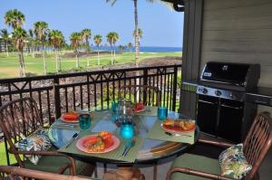 ein Tisch mit Tellern voller Essen auf einem Balkon in der Unterkunft Halii Kai 9G in Waikoloa