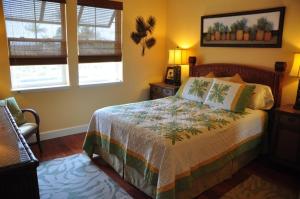 ein Schlafzimmer mit einem Bett und zwei Fenstern in der Unterkunft Halii Kai 9G in Waikoloa