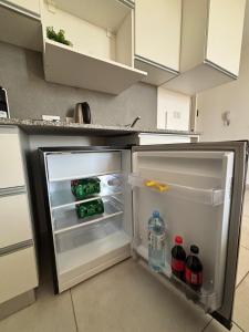 an open refrigerator in a kitchen with drinks in it at Studio for Tourism or Business Trip in Corrientes