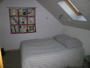 a small bed in a room with a window at Ti Gwen in Plonévez-du-Faou