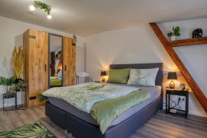 a bedroom with a king sized bed in a room at Zuarin Seeblick - Ganzes Apartment direkt am Schlossgarten von Schwerin mit Dschungelfeeling in Schwerin