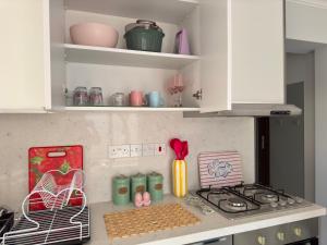 a kitchen with white cabinets and a stove top oven at Lavender Homes Iskele - Cosy Studio with Pool in Famagusta
