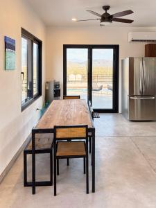 a large wooden table in a kitchen with a refrigerator at 2 Casas and Pool- Walk to Beach, Great for Groups in El Pescadero