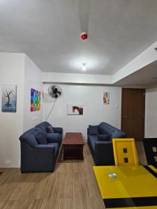 a living room with two blue couches and a table at Pine suite Condo Tagaytay in Tagaytay