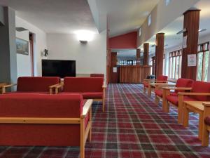 a waiting room with red chairs and a flat screen tv at Bushmills Hostel in Bushmills