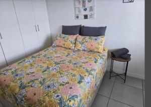 开普敦Sunset at Keys的一间卧室配有一张带五颜六色的被子和凳子的床 更多22张照片