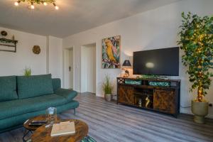 a living room with a couch and a flat screen tv at Zuarin Seeblick - Ganzes Apartment direkt am Schlossgarten von Schwerin mit Dschungelfeeling in Schwerin