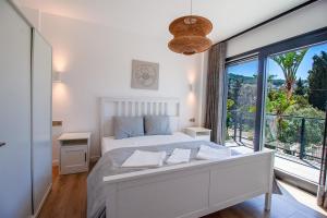 a bedroom with a white bed and a large window at Villa Casa LUZ in Bodrum City +24 photos