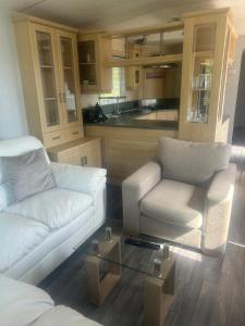 a living room with a couch and a chair and a table at Southview cedar bank 6 in Skegness