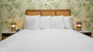 格伦代尔The LEEF Hotel的卧室内的一张带白色枕头和两盏灯的床